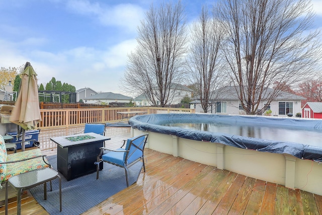 deck with a fire pit and a covered pool