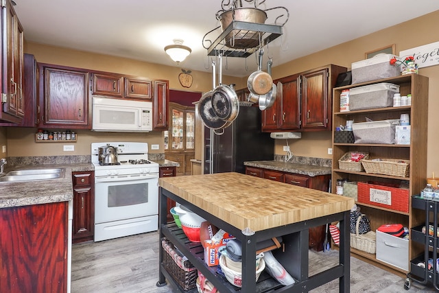 kitchen featuring white appliances, light hardwood / wood-style floors, and sink