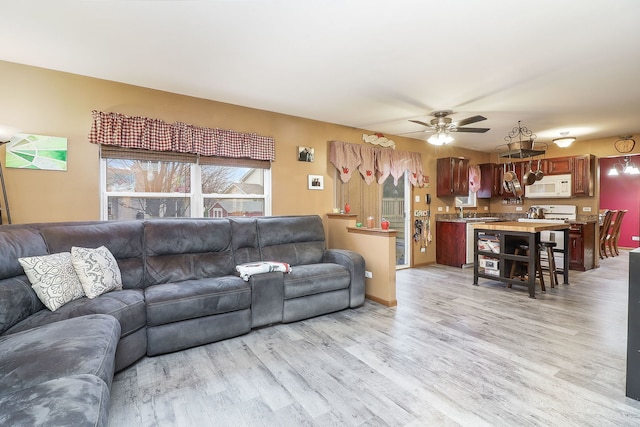 living room with light hardwood / wood-style flooring and ceiling fan