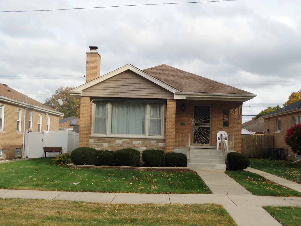 bungalow featuring a front lawn