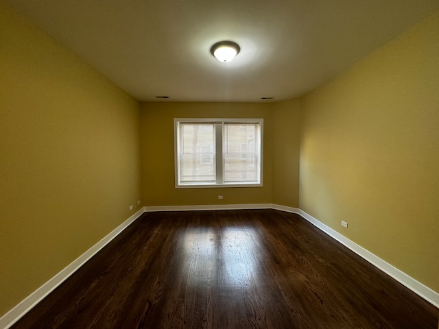 unfurnished room with dark hardwood / wood-style flooring