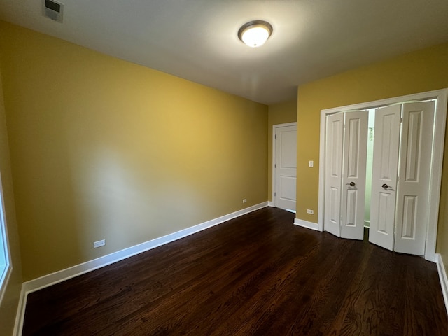 unfurnished bedroom with dark hardwood / wood-style flooring