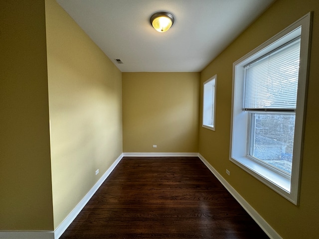 empty room with dark hardwood / wood-style flooring