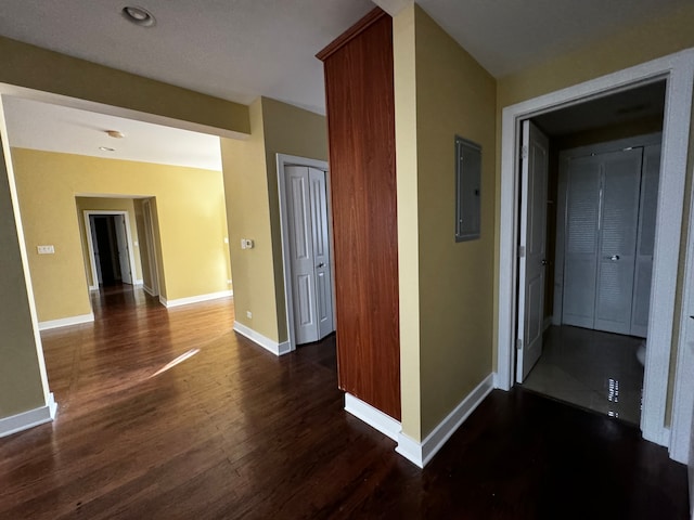 hall with dark wood-type flooring and electric panel