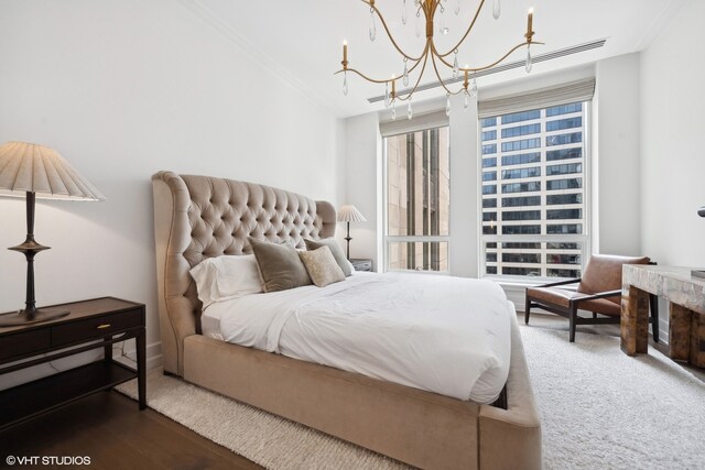 bedroom with a chandelier, hardwood / wood-style flooring, and crown molding