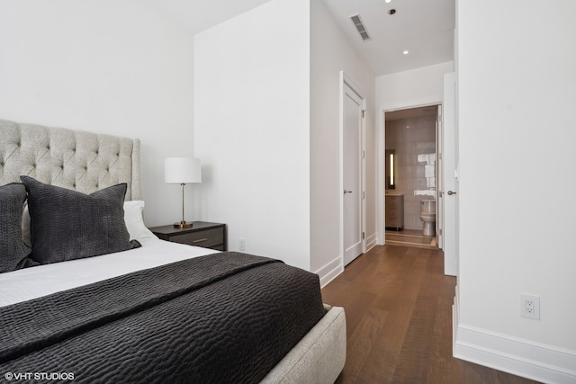 bedroom with connected bathroom and dark hardwood / wood-style floors