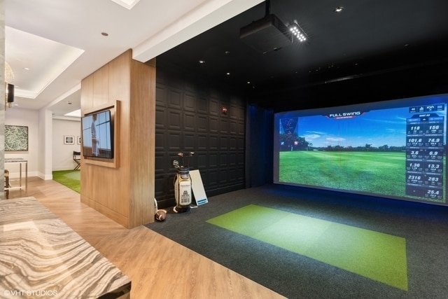 game room with wood-type flooring, golf simulator, and wooden walls