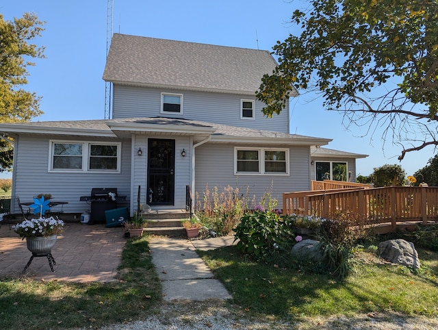 view of front of home with a wooden deck and a patio area