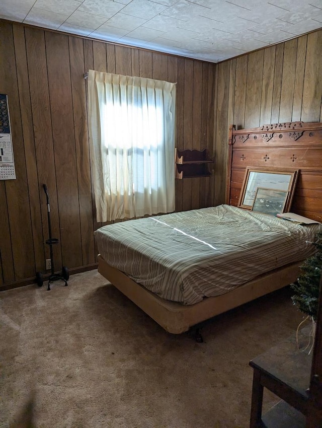 carpeted bedroom featuring wooden walls