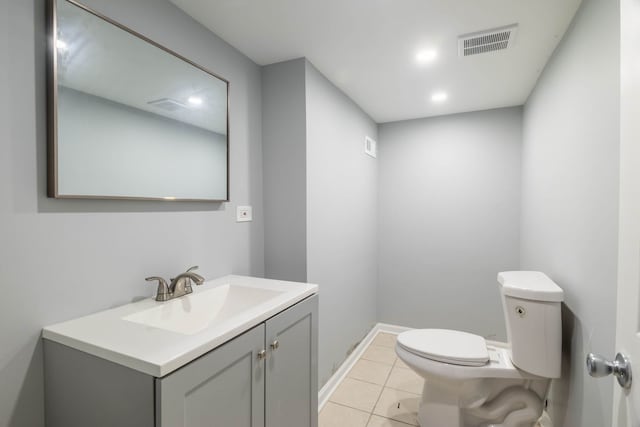 bathroom with toilet, vanity, and tile patterned floors