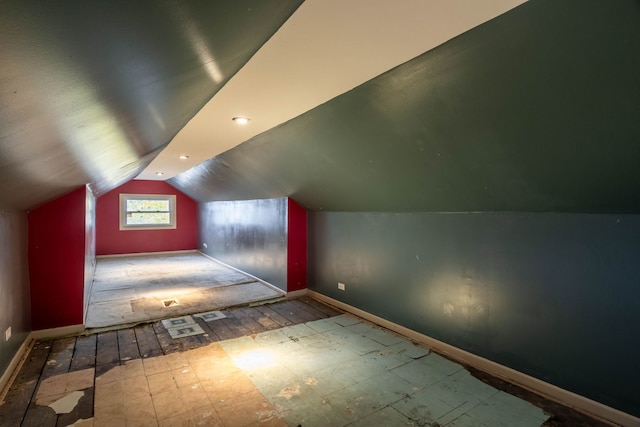 additional living space featuring light hardwood / wood-style floors and vaulted ceiling