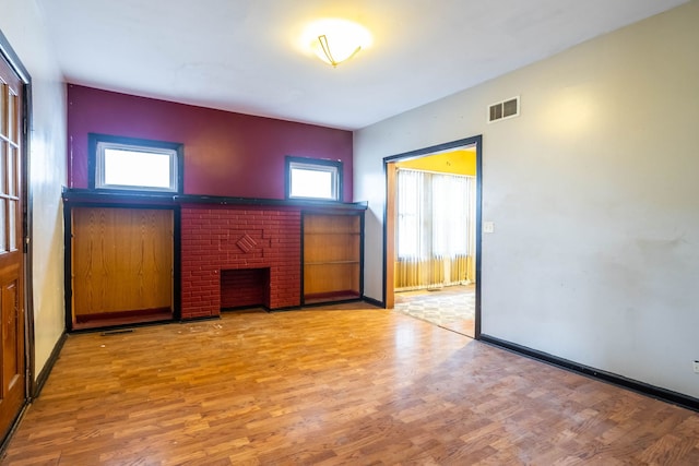 unfurnished room with a fireplace and light hardwood / wood-style floors