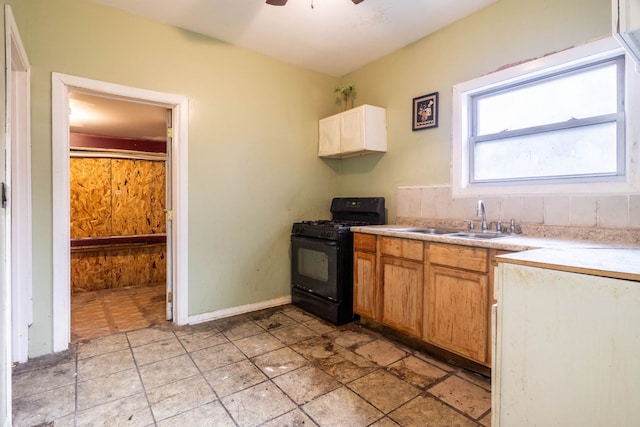 kitchen with ceiling fan, black gas stove, and sink