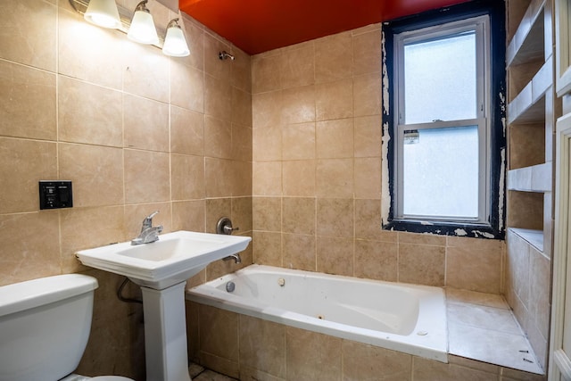 bathroom featuring toilet, tile walls, and tiled tub