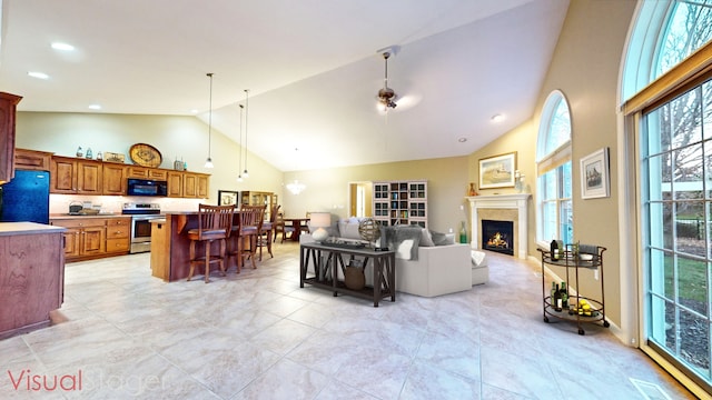 living room featuring ceiling fan and high vaulted ceiling