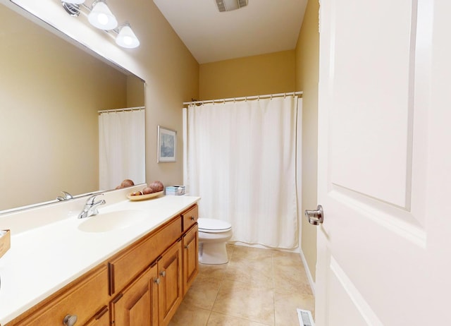 bathroom with toilet, vanity, and tile patterned flooring