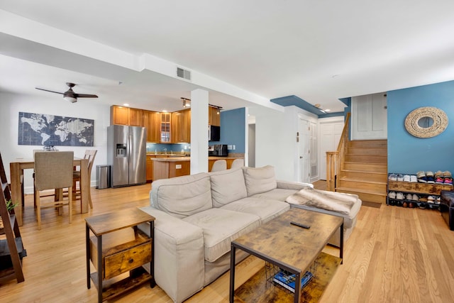 living room with light hardwood / wood-style floors and ceiling fan