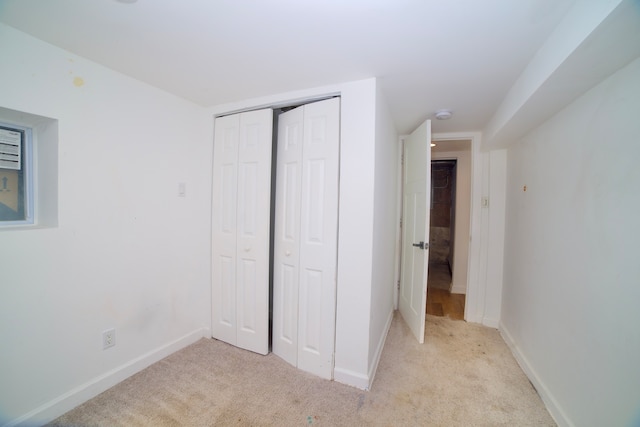 unfurnished bedroom with light carpet and a closet