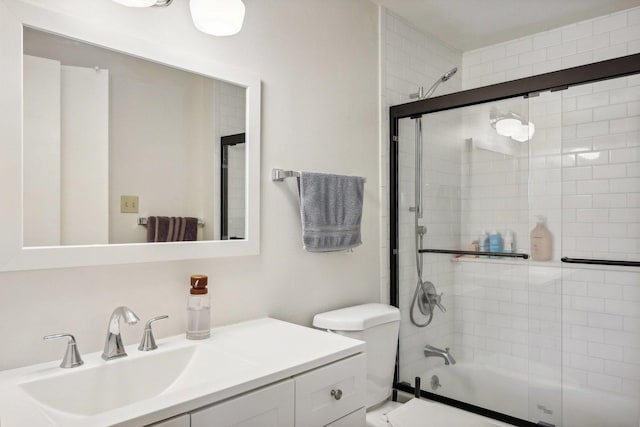 full bathroom with vanity, bath / shower combo with glass door, and toilet