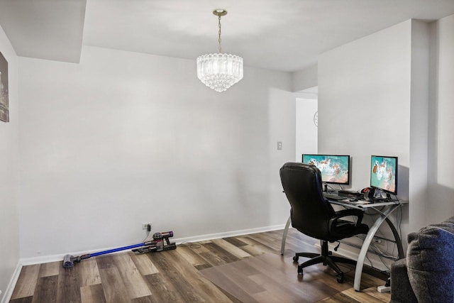 home office with hardwood / wood-style flooring and a notable chandelier