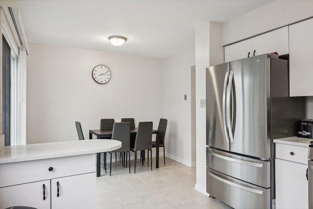 kitchen featuring light tile patterned floors, white cabinetry, and stainless steel refrigerator