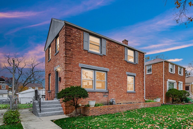 property exterior at dusk featuring a lawn