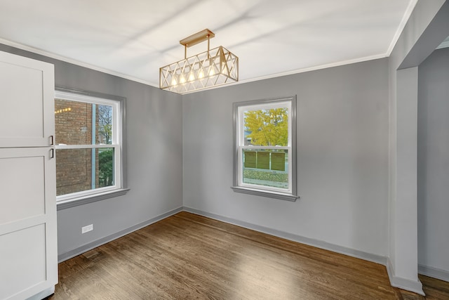 spare room featuring crown molding and dark wood-type flooring