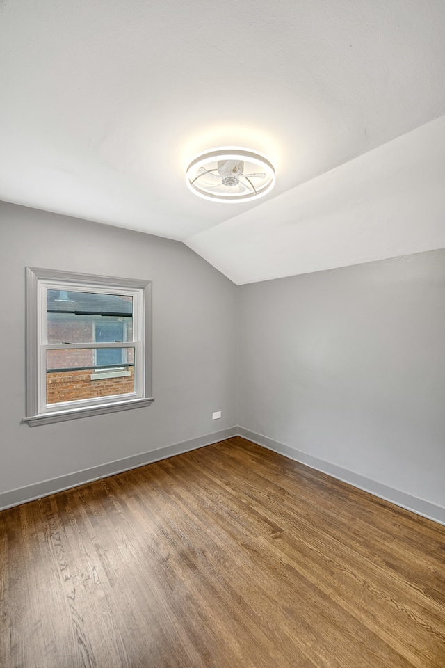 bonus room with hardwood / wood-style floors and vaulted ceiling