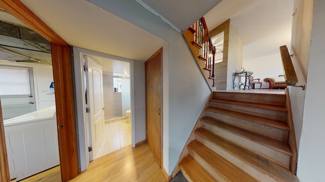 stairway with washer / dryer, hardwood / wood-style flooring, and plenty of natural light