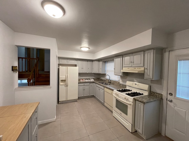 kitchen featuring light tile patterned floors, white appliances, gray cabinets, and sink