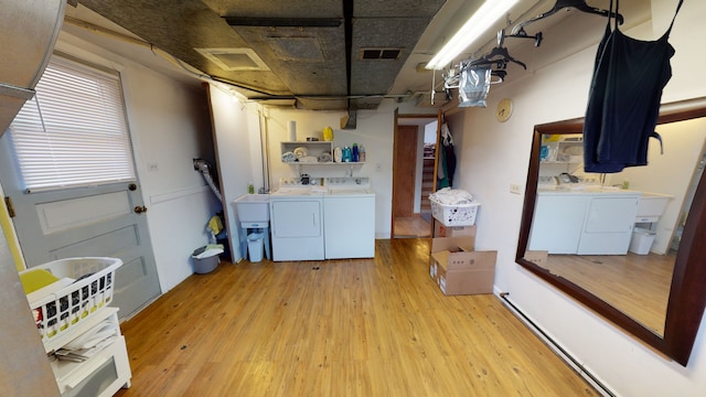 laundry room with light wood-type flooring and washing machine and dryer