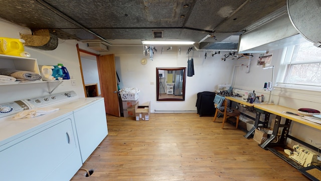 laundry area featuring independent washer and dryer, a workshop area, and light hardwood / wood-style flooring