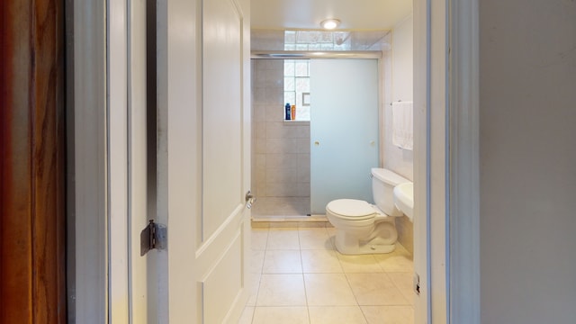 bathroom with tile patterned floors, walk in shower, and toilet