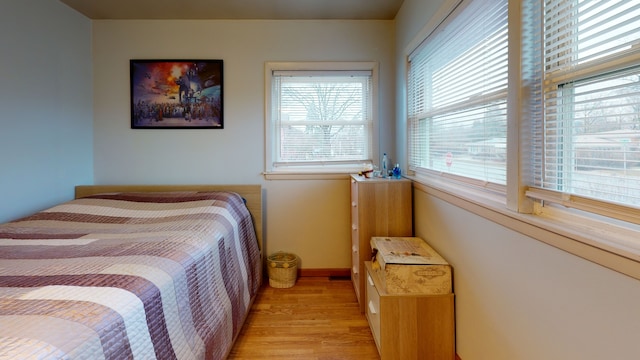 bedroom with light wood-type flooring and multiple windows