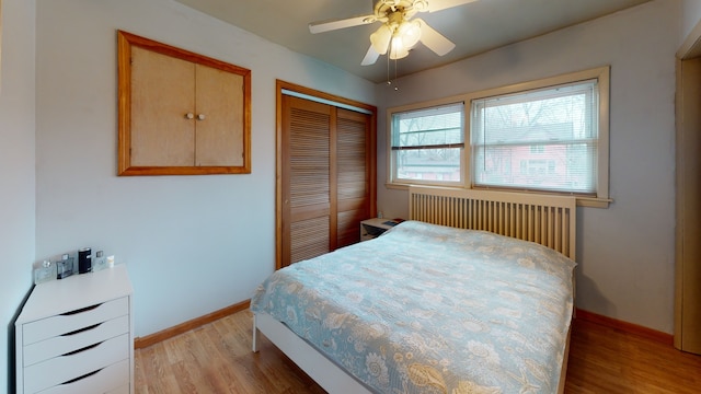 bedroom featuring radiator heating unit, light hardwood / wood-style flooring, a closet, and ceiling fan