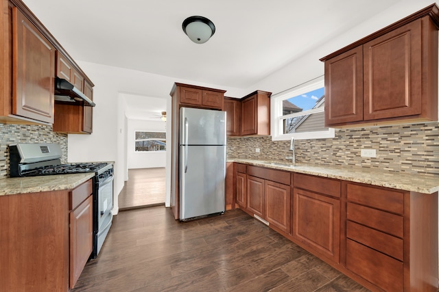 kitchen with tasteful backsplash, range with gas cooktop, dark wood-type flooring, sink, and stainless steel refrigerator