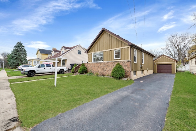 view of front of home featuring a garage, a front lawn, and an outdoor structure