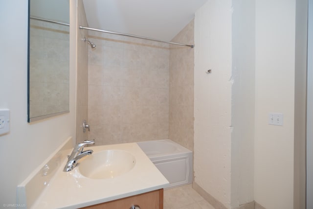 bathroom featuring tile patterned flooring, vanity, and tiled shower / bath