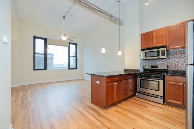 kitchen with ceiling fan, tasteful backsplash, kitchen peninsula, light hardwood / wood-style floors, and appliances with stainless steel finishes