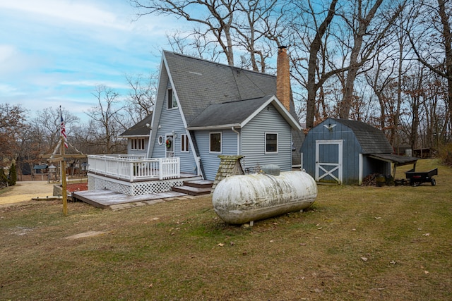 rear view of house with a yard, a shed, and a deck