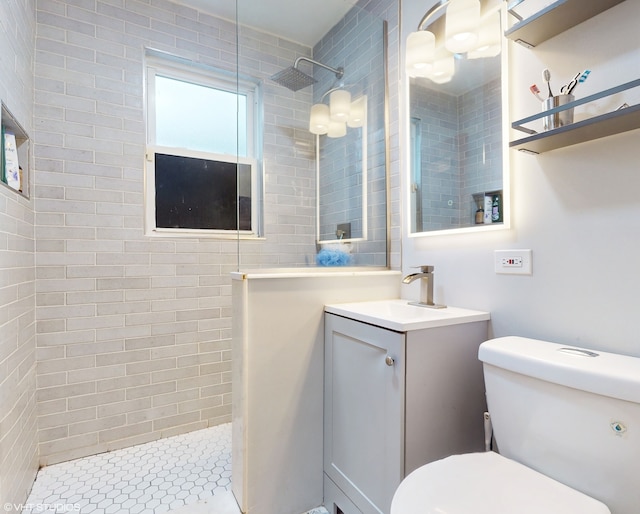 bathroom with vanity, toilet, and a tile shower