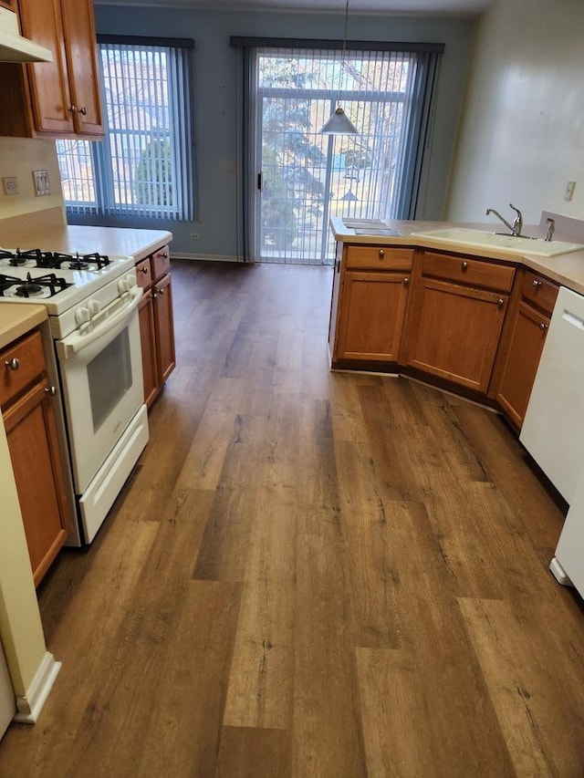 kitchen featuring pendant lighting, sink, white appliances, and a wealth of natural light