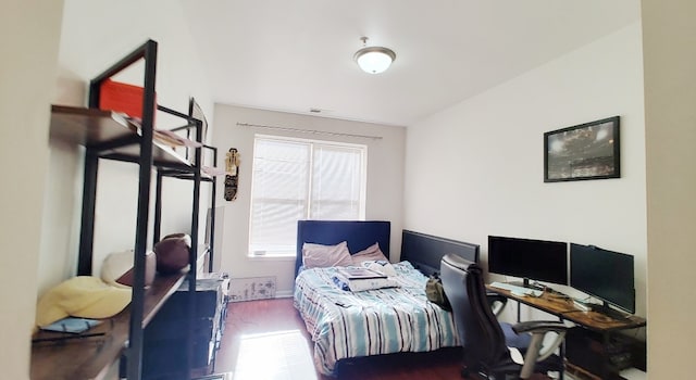 bedroom with wood-type flooring and multiple windows