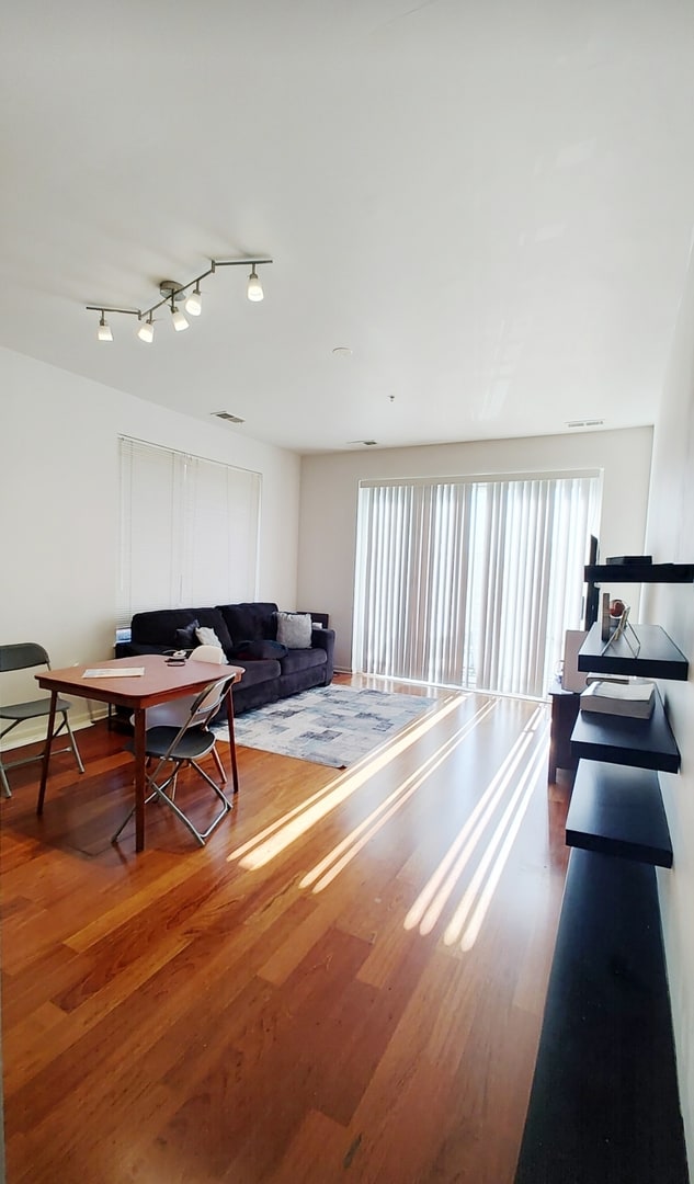 living room with rail lighting and hardwood / wood-style flooring