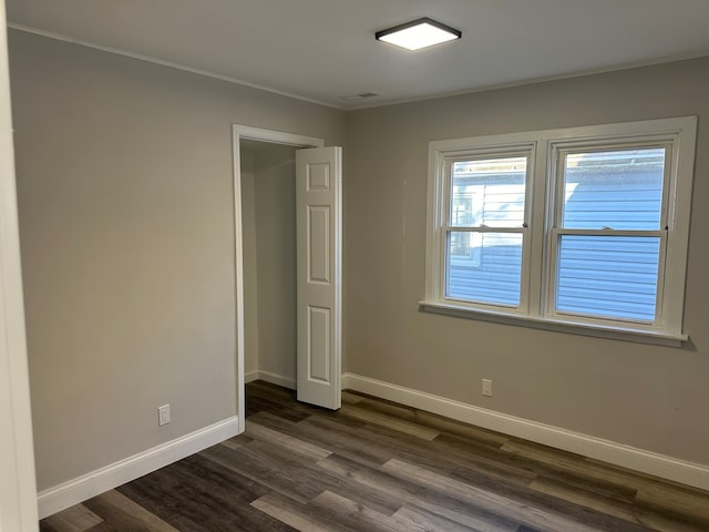 unfurnished bedroom featuring dark hardwood / wood-style floors and ornamental molding