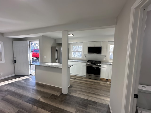 kitchen with dark hardwood / wood-style flooring, white cabinets, and appliances with stainless steel finishes