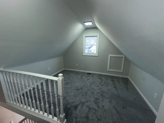 bonus room with lofted ceiling and carpet floors