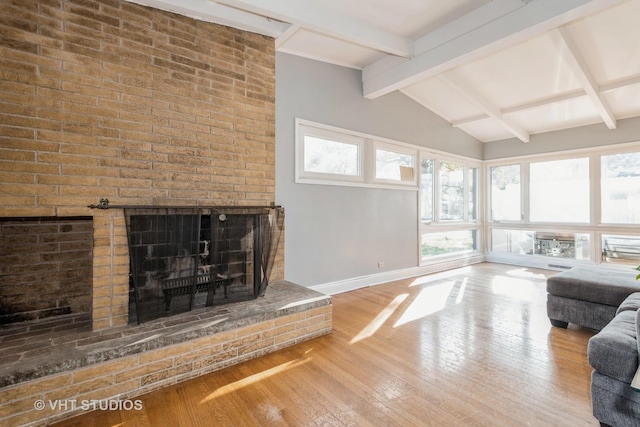 living room with vaulted ceiling with beams, a fireplace, and hardwood / wood-style flooring