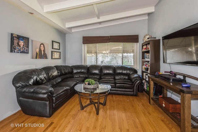 living room with lofted ceiling with beams and light hardwood / wood-style flooring