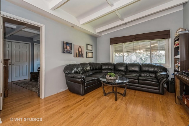 living room with light hardwood / wood-style flooring and vaulted ceiling with beams